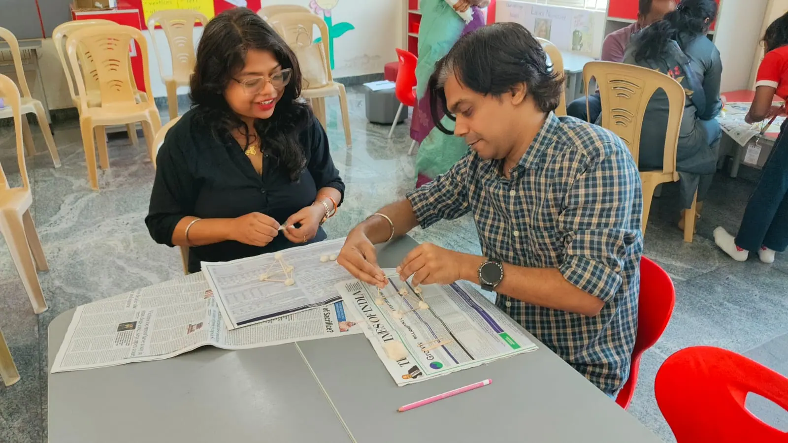 Parents building models with sticks during a hands-on parent workshop