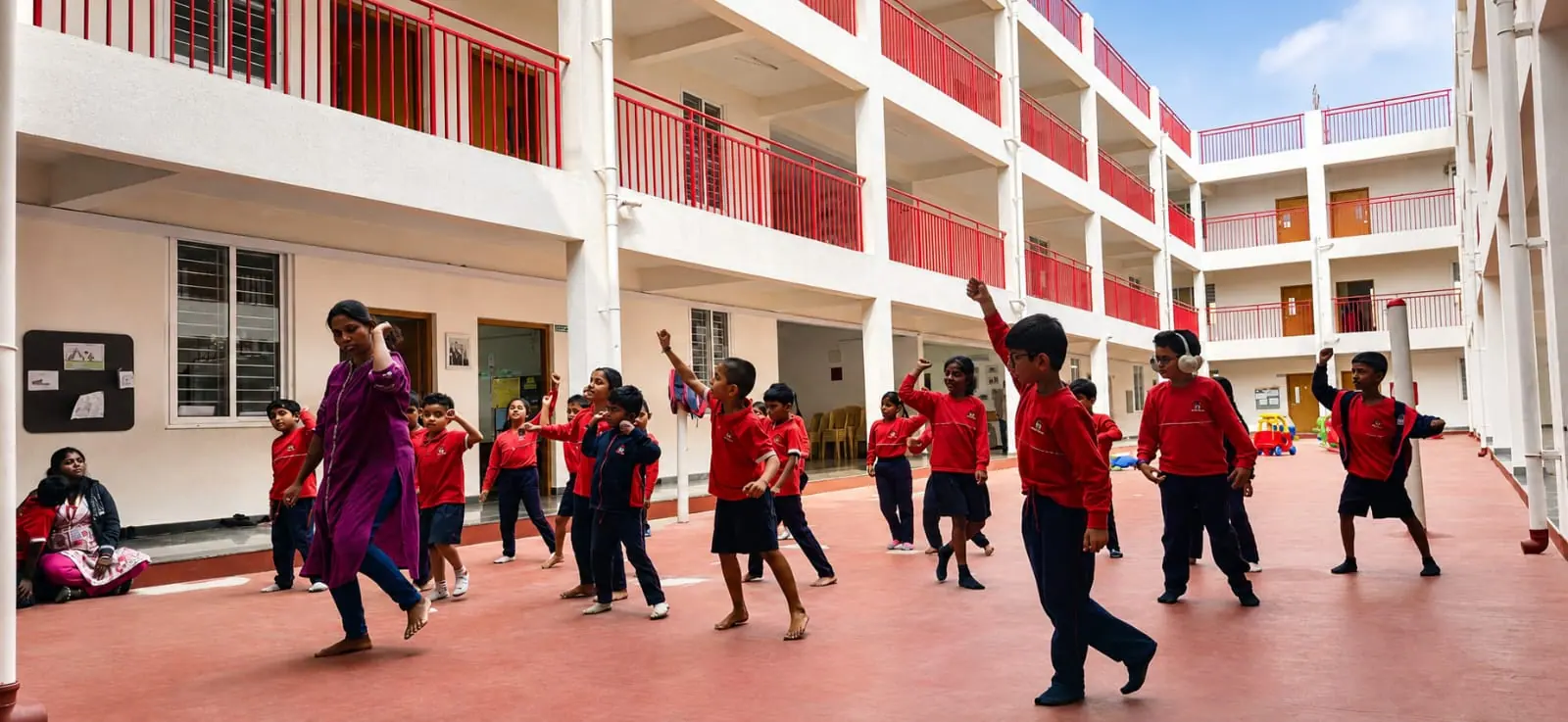 Students in school uniform dancing together in the courtyard