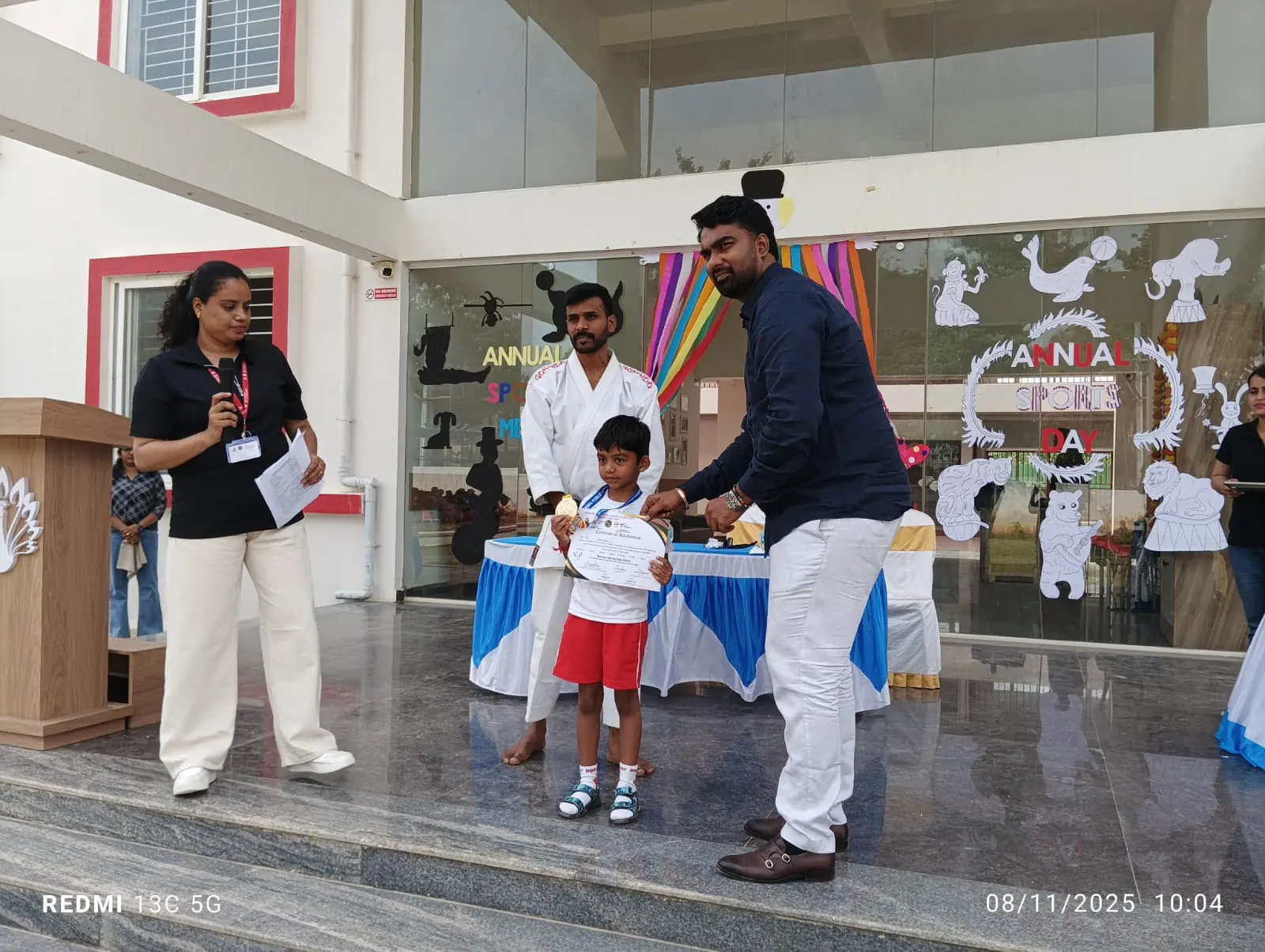 A young student receiving a certificate and medal at the Annual Sports Day