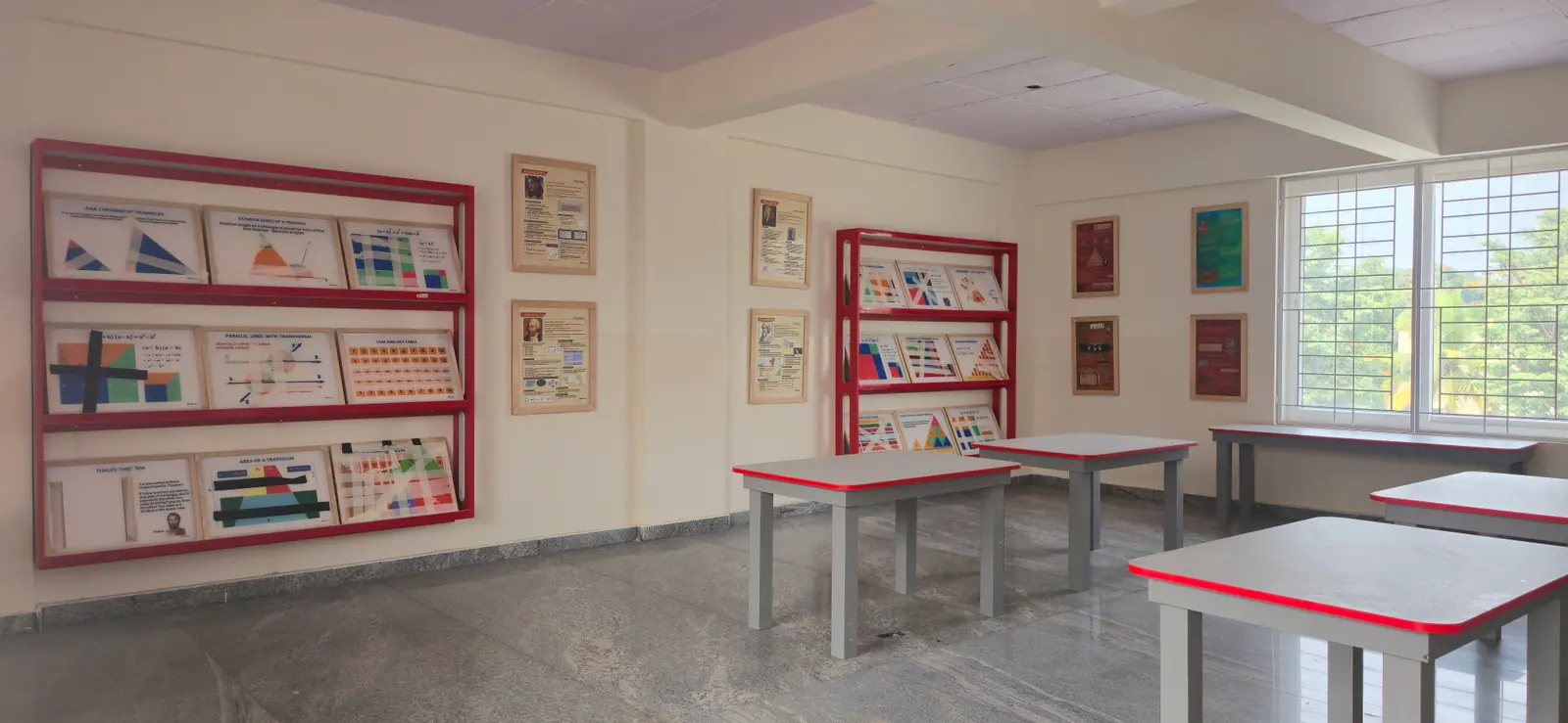 Resource room with maths charts on red display racks and work tables