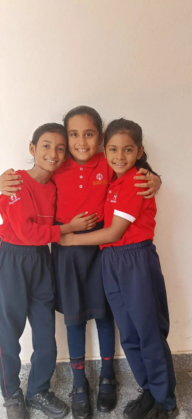 Three students in school uniform standing together