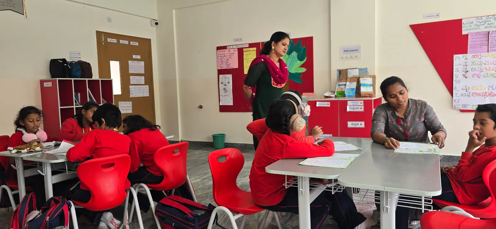 A teacher guiding a small group of students at their desks
