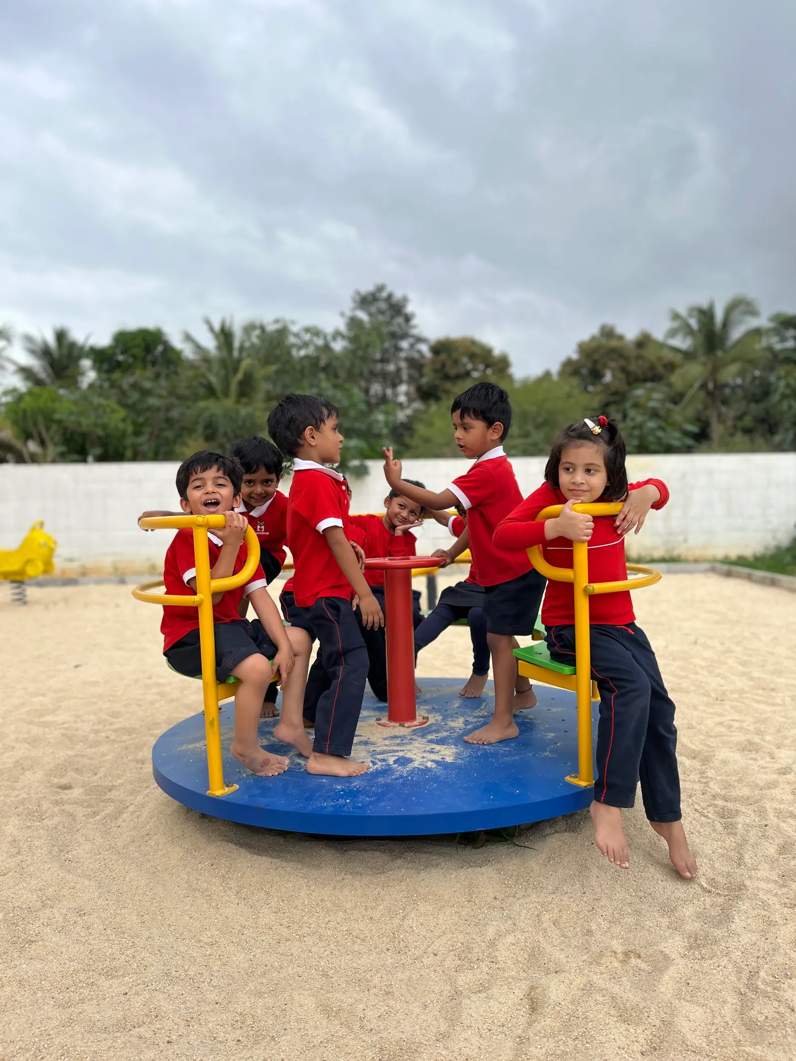 Children spinning together on the playground merry-go-round