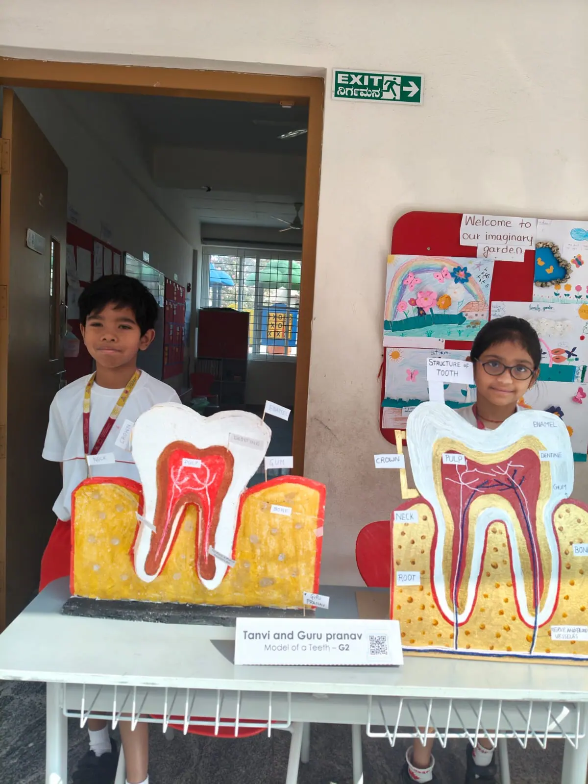 Students presenting science project models at a school exhibition