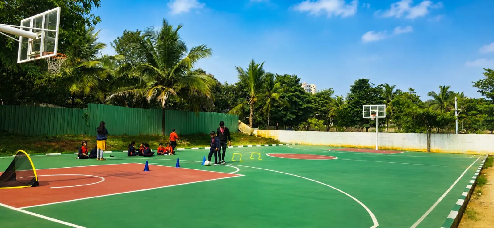 Students practising football skills on the school sports court